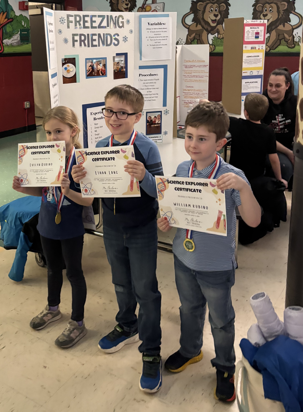 Three Center Elementary School students hold up certificates acknowledging their participation in the annual science fair on March 11, 2026.